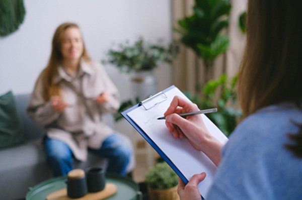 Nutritionniste prend des notes devant son patient.