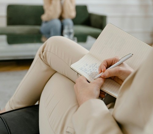 Femme prenant des notes sur un cahier.